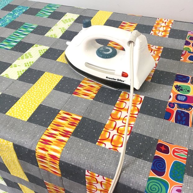 Iron the basted quilt to set the glue